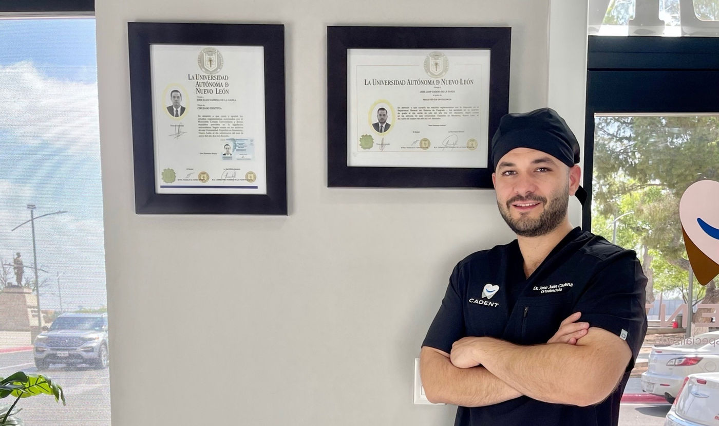 Dr. José Juan Cadena De La Garza junto a sus títulos universitarios de la UANL: Cirujano Dentista y Maestría en Ortodoncia
